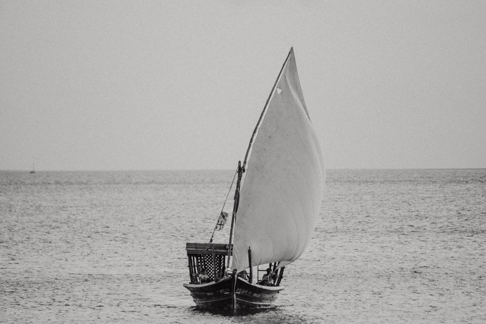 Traditional Zanzibar dhow sailing boat with white lateen sail on the Indian Ocean